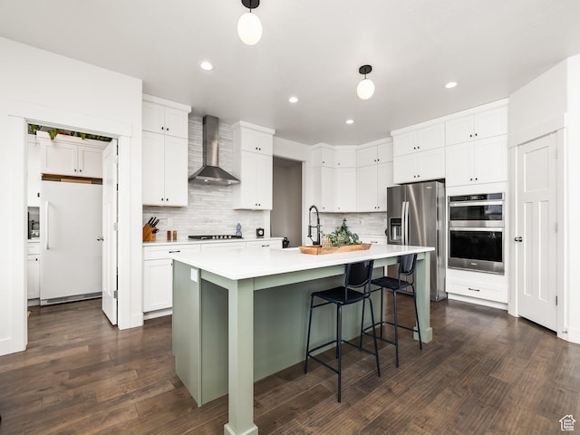 4823 N Canaan Peak Dr W, Eagle Mountain, UT 84005 - kitchen with appliances with stainless steel finishes, wall chimney range hood, light countertops, tasteful backsplash, and recessed lighting
