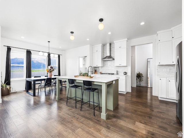 4823 N Canaan Peak Dr W, Eagle Mountain, UT 84005 - kitchen featuring wall chimney range hood, tasteful backsplash, light countertops, a breakfast bar area, and recessed lighting