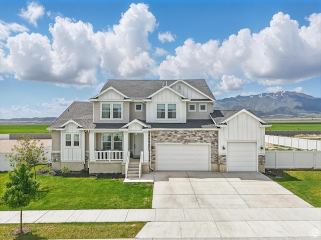 4823 N Canaan Peak Dr W, Eagle Mountain, UT 84005 - craftsman-style home with board and batten siding, a mountain view, covered porch, driveway, and roof with shingles