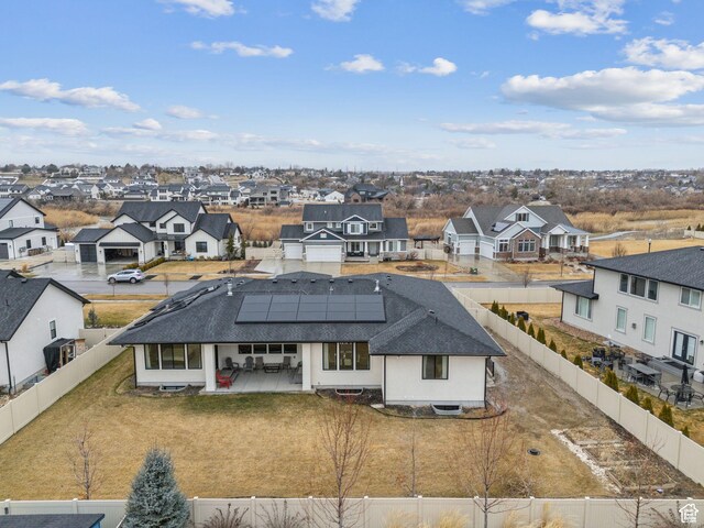 11603 S Fox Vista Dr, Draper, UT 84020 - back of property featuring a residential view, a fenced backyard, roof mounted solar panels, a shingled roof, and a patio