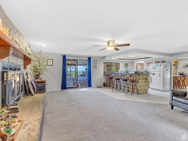 5104 Shawnee Ln, Ogden, UT 84403 - living room featuring a ceiling fan, light carpet, a textured ceiling, bar area, and light tile patterned floors