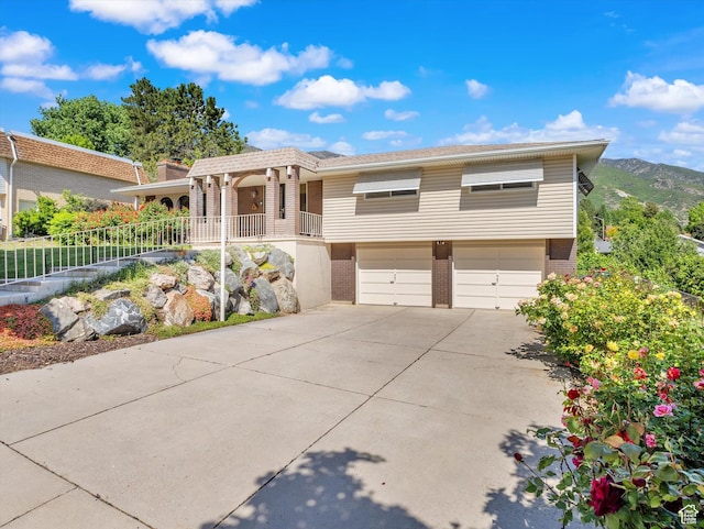 5104 Shawnee Ln, Ogden, UT 84403 - view of front of property featuring a garage, concrete driveway, brick siding, and covered porch