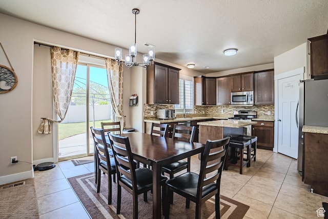3907 W Tottori Dune Dr S, South Jordan, UT 84095 - dining space with a chandelier, light tile patterned floors, baseboards, and a textured ceiling