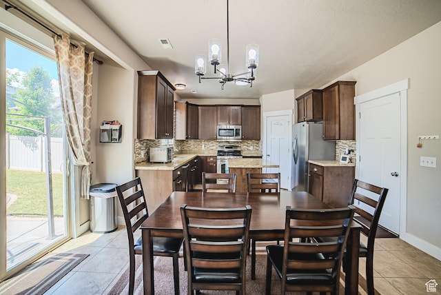 3907 W Tottori Dune Dr S, South Jordan, UT 84095 - dining area with light tile patterned floors, a chandelier, and baseboards