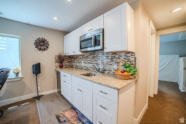 3907 W Tottori Dune Dr S, South Jordan, UT 84095 - kitchen with stainless steel microwave, a sink, baseboards, decorative backsplash, and white cabinetry
