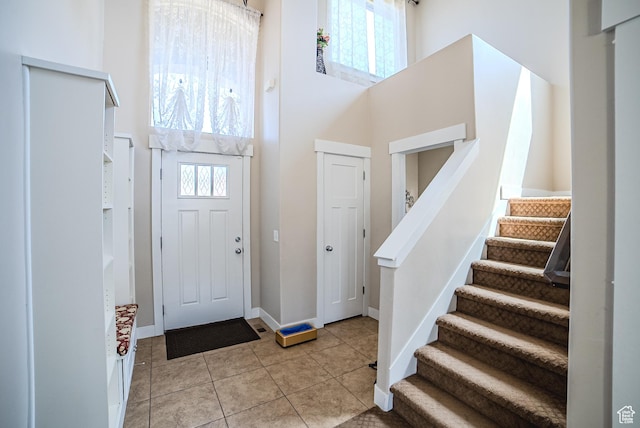 3907 W Tottori Dune Dr S, South Jordan, UT 84095 - entrance foyer with a towering ceiling, stairs, light tile patterned floors, and baseboards