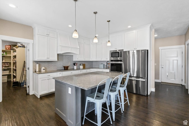 495 E 100 S, Centerfield, UT 84622 - kitchen featuring appliances with stainless steel finishes, dark wood-style flooring, light stone countertops, a kitchen island, and tasteful backsplash