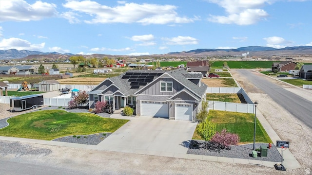 495 E 100 S, Centerfield, UT 84622 - view of front of house featuring board and batten siding, roof mounted solar panels, a mountain view, concrete driveway, and an attached garage