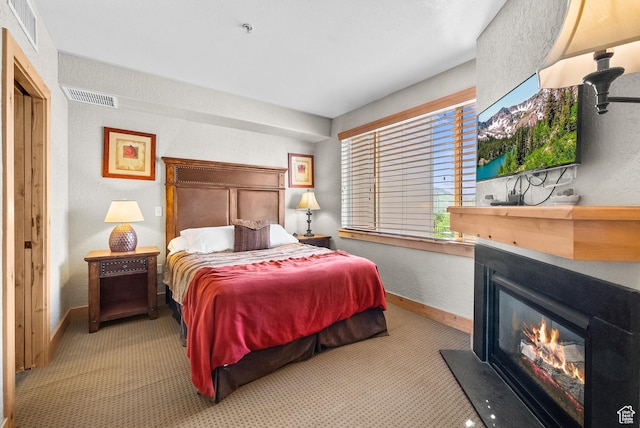2669 Canyons Resort Dr Unit 304A, Park City, UT 84098 - bedroom with carpet flooring, a textured wall, a glass covered fireplace, and baseboards