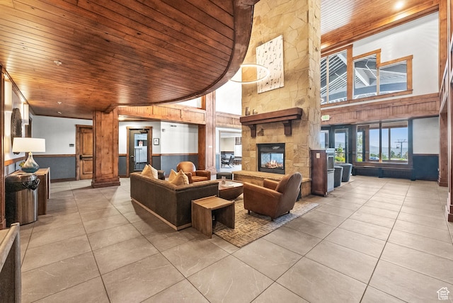 2669 Canyons Resort Dr Unit 304A, Park City, UT 84098 - living room with wood ceiling, a towering ceiling, a wainscoted wall, tile patterned flooring, and a fireplace