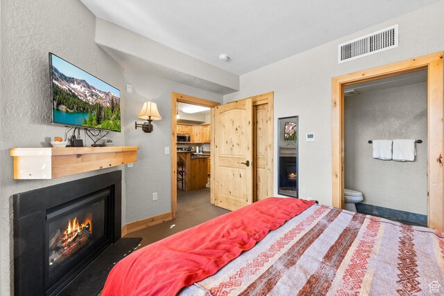 2669 Canyons Resort Dr Unit 304A, Park City, UT 84098 - carpeted bedroom featuring a fireplace with flush hearth, ensuite bathroom, a textured wall, a closet, and baseboards