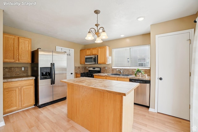802 E 580 N, Tooele, UT 84074 - kitchen featuring stainless steel appliances, a sink, light wood finished floors, a kitchen island, and a chandelier