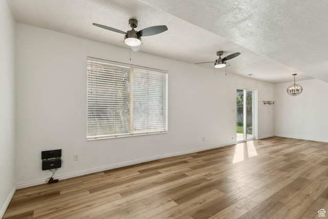 256 Jay Ln, Payson, UT 84651 - empty room with ceiling fan, light wood-style flooring, a chandelier, a textured ceiling, and baseboards