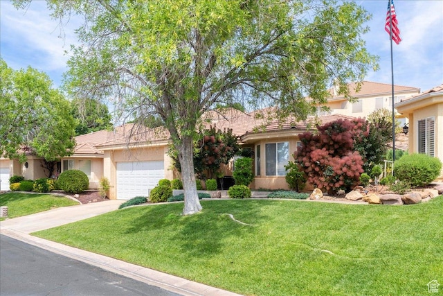 2050 S 1400 E Unit 13, St George, UT 84790 - view of property hidden behind natural elements featuring an attached garage, stucco siding, concrete driveway, and a front lawn