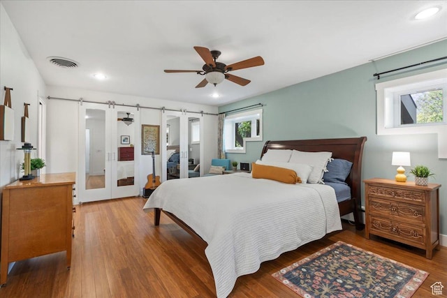 971 E Village Way, Alpine, UT 84004 - bedroom featuring multiple windows, wood finished floors, recessed lighting, a ceiling fan, and a barn door