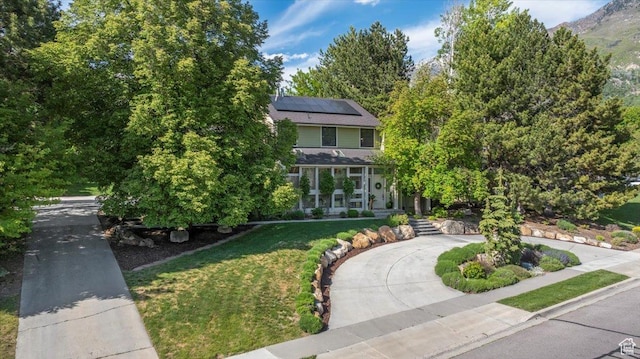 971 E Village Way, Alpine, UT 84004 - obstructed view of property with curved driveway, solar panels, and a front yard