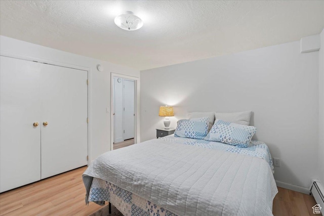 971 E Village Way, Alpine, UT 84004 - bedroom with a baseboard heating unit, wood finished floors, baseboards, a textured ceiling, and multiple closets