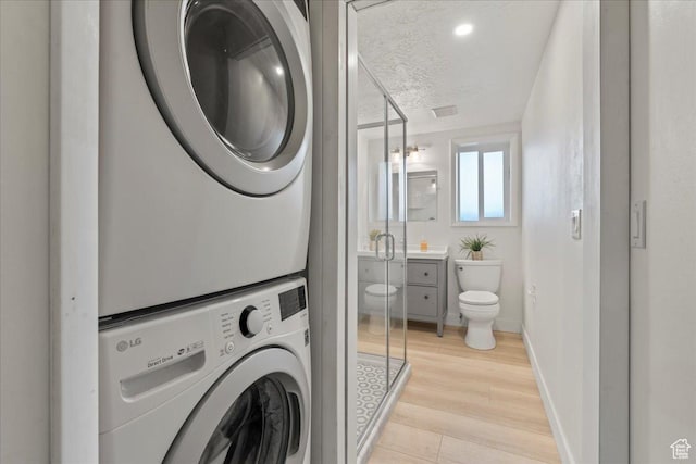 971 E Village Way, Alpine, UT 84004 - washroom with estacked washer and dryer, light wood-type flooring, and baseboards