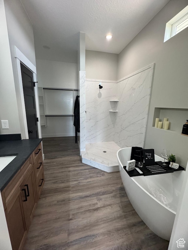 565 E Otto Ln Unit 421, Grantsville, UT 84029 - bathroom featuring a marble finish shower, vanity, a soaking tub, wood finished floors, and a textured ceiling