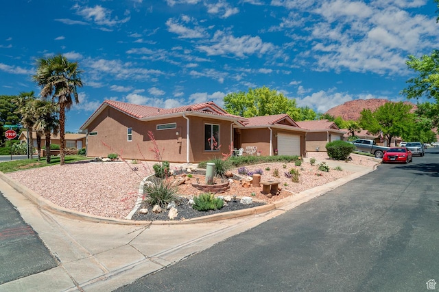 576 S Fiesta Dr, Ivins, UT 84738 - ranch-style house with a garage, a tile roof, and stucco siding