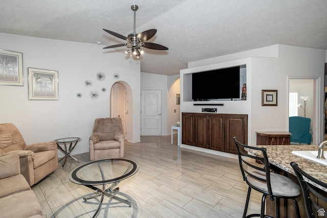 576 S Fiesta Dr, Ivins, UT 84738 - living area featuring arched walkways, ceiling fan, a textured ceiling, and baseboards