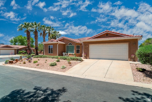 576 S Fiesta Dr, Ivins, UT 84738 - view of front of property featuring a garage, driveway, a tiled roof, and stucco siding