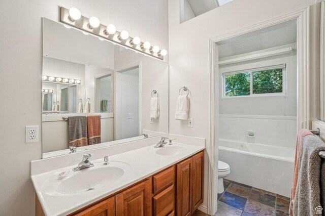 4538 Cottage Grove Ln, Murray, UT 84107 - bathroom featuring toilet, stone finish floors, double vanity, and a tub