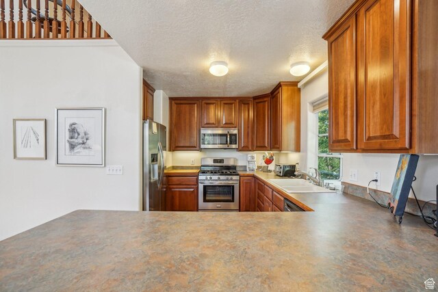 4538 Cottage Grove Ln, Murray, UT 84107 - kitchen featuring appliances with stainless steel finishes, a sink, a textured ceiling, and brown cabinets