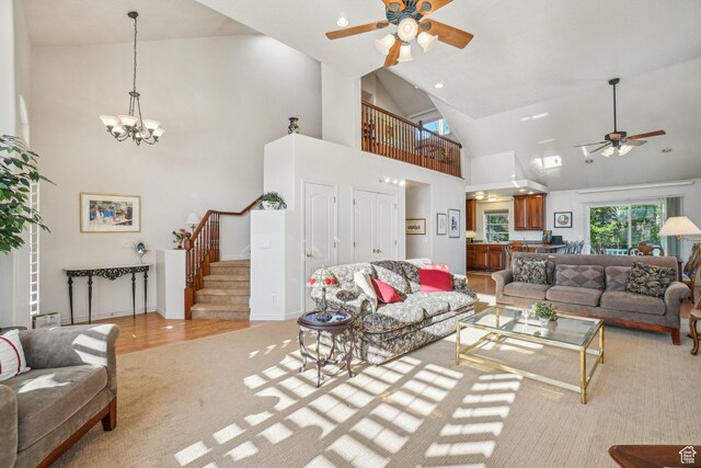 4538 Cottage Grove Ln, Murray, UT 84107 - living room featuring ceiling fan, stairs, a chandelier, high vaulted ceiling, and light carpet