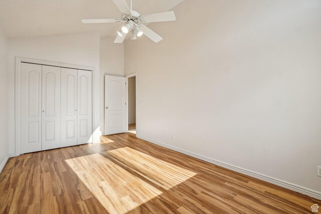 4538 Cottage Grove Ln, Murray, UT 84107 - unfurnished bedroom featuring baseboards, light wood-type flooring, a closet, high vaulted ceiling, and ceiling fan