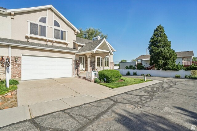 4538 Cottage Grove Ln, Murray, UT 84107 - view of front facade featuring an attached garage, driveway, brick siding, and stucco siding