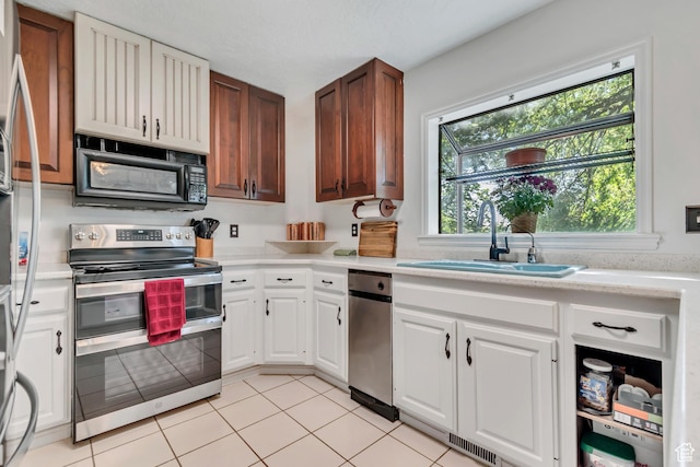 1789 N Stayner Dr W, Farmington, UT 84025 - kitchen with stainless steel appliances, a sink, light countertops, light tile patterned floors, and white cabinets