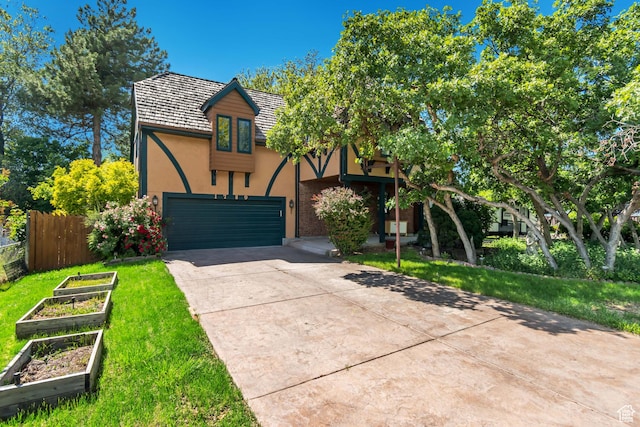 1789 N Stayner Dr W, Farmington, UT 84025 - english style home featuring stucco siding, concrete driveway, a garden, and an attached garage