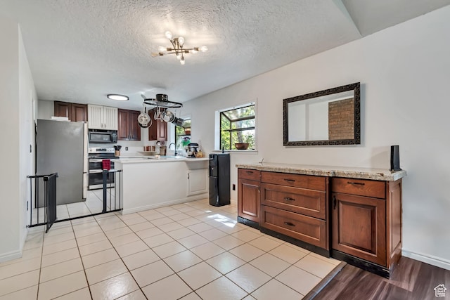 1789 N Stayner Dr W, Farmington, UT 84025 - kitchen featuring appliances with stainless steel finishes, light countertops, a chandelier, a textured ceiling, and baseboards
