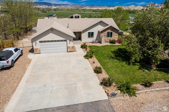 113 E 1500 N, Vernal, UT 84078 - ranch-style house featuring stone siding, an attached garage, driveway, and a front lawn