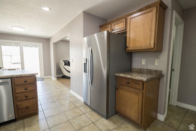113 E 1500 N, Vernal, UT 84078 - kitchen featuring appliances with stainless steel finishes, brown cabinetry, baseboards, and light tile patterned flooring