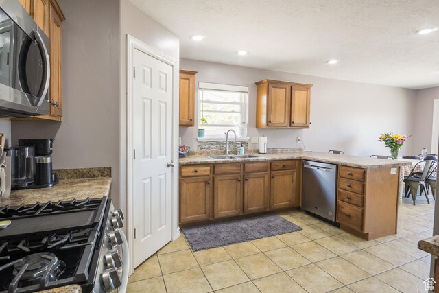 113 E 1500 N, Vernal, UT 84078 - kitchen featuring appliances with stainless steel finishes, a sink, a peninsula, brown cabinets, and light countertops