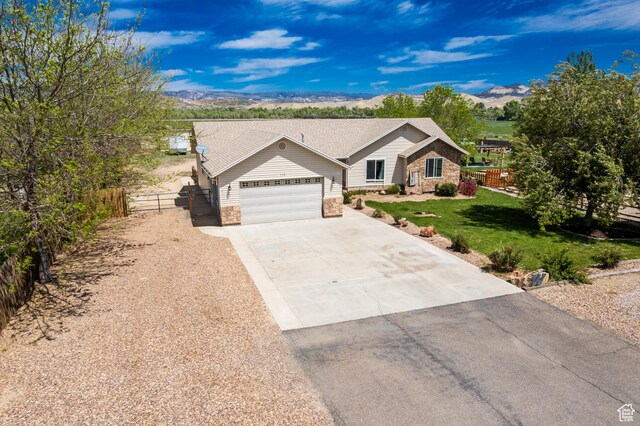 113 E 1500 N, Vernal, UT 84078 - ranch-style home featuring stone siding, an attached garage, driveway, and a mountain view