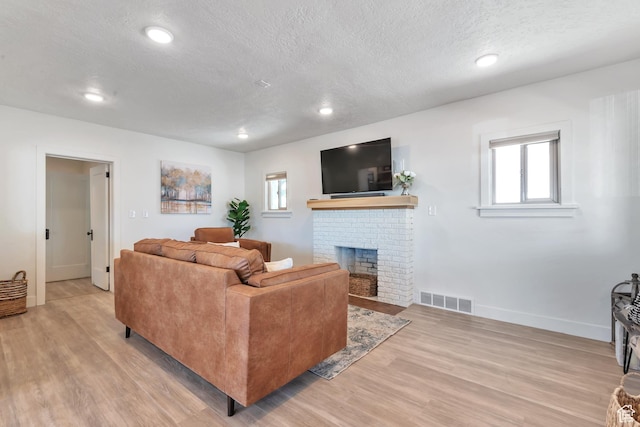 292 S 100 W, Provo, UT 84601 - living area with a textured ceiling, light wood-style flooring, plenty of natural light, a brick fireplace, and recessed lighting