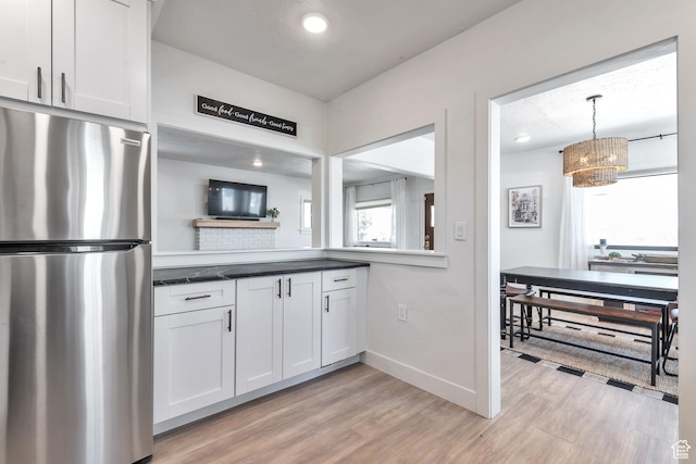 292 S 100 W, Provo, UT 84601 - kitchen featuring freestanding refrigerator, light wood-style flooring, white cabinetry, dark countertops, and hanging light fixtures