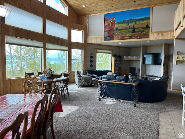 1940 E Shore Rd, Saint Charles, ID 83272 - living room featuring high vaulted ceiling, light colored carpet, wood walls, and light tile patterned floors