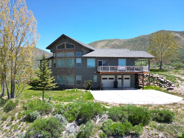 1940 E Shore Rd, Saint Charles, ID 83272 - view of front of property with a garage, concrete driveway, a mountain view, and a front lawn