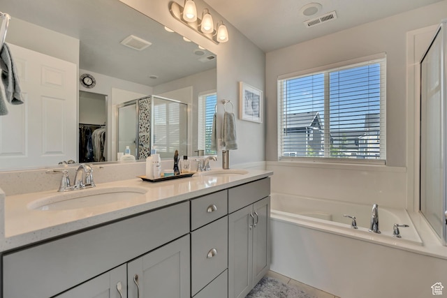 5058 W Blythswood Ln S, Herriman, UT 84096 - full bathroom featuring a stall shower, a bath, double vanity, a walk in closet, and tile patterned flooring