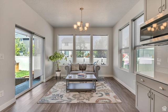 5058 W Blythswood Ln S, Herriman, UT 84096 - living area with a chandelier, dark wood-type flooring, plenty of natural light, a textured ceiling, and baseboards