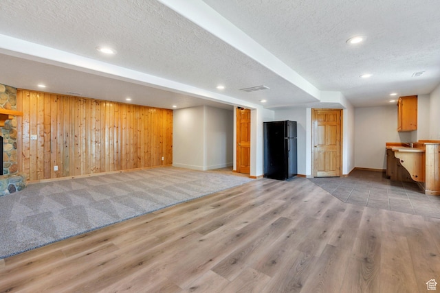 69 E Hudson Dr, Elk Ridge, UT 84651 - unfurnished living room featuring a textured ceiling, baseboards, light wood-style flooring, wood walls, and recessed lighting
