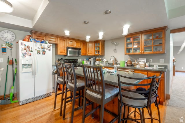 1995 E 6225 S, South Ogden, UT 84403 - kitchen featuring white fridge with ice dispenser, brown cabinets, electric range, dark countertops, and a breakfast bar