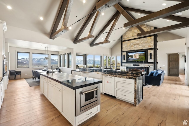 8982 N Mountain Crest Rd, Park City, UT 84098 - kitchen featuring a large island with sink, a sink, beam ceiling, high vaulted ceiling, and open floor plan