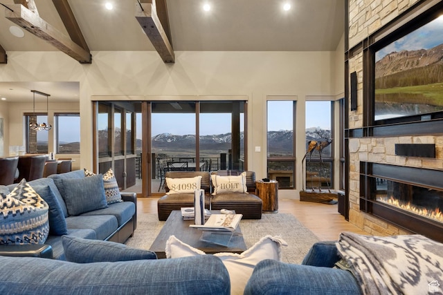 8982 N Mountain Crest Rd, Park City, UT 84098 - living room with beamed ceiling, a stone fireplace, recessed lighting, wood finished floors, and a high ceiling