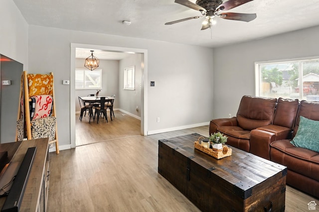 2411 S D Ave E, Ogden, UT 84401 - living area featuring light wood finished floors, healthy amount of natural light, ceiling fan, and baseboards
