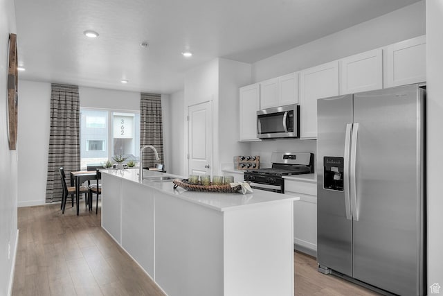 412 S 1110 W Unit 215, American Fork, UT 84003 - kitchen featuring appliances with stainless steel finishes, a sink, white cabinets, a kitchen island with sink, and light wood-style floors